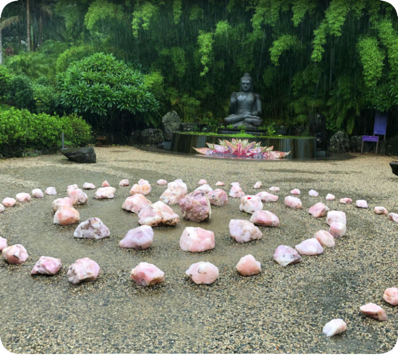 Pierres rosées, Bouddha et lotus. Pierres rosées en tourbillon sur le sol avec un Bouddha et un lotu en arrière-plan.